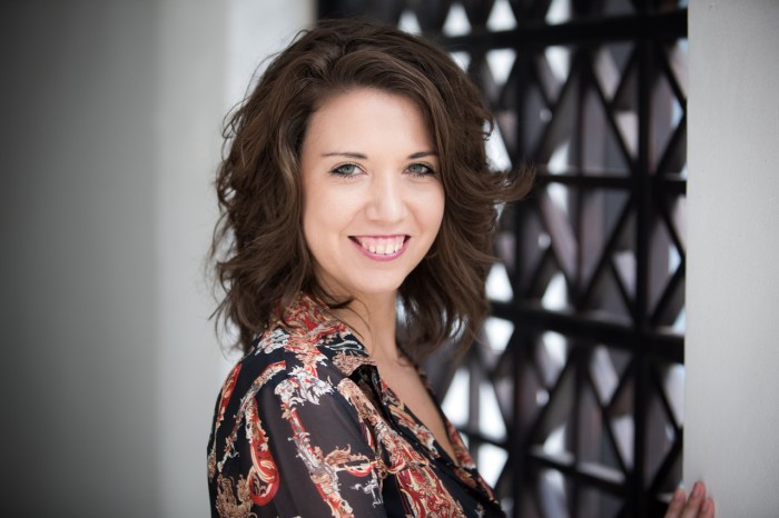 Upper body shot of woman half turned towards the camera and smiling