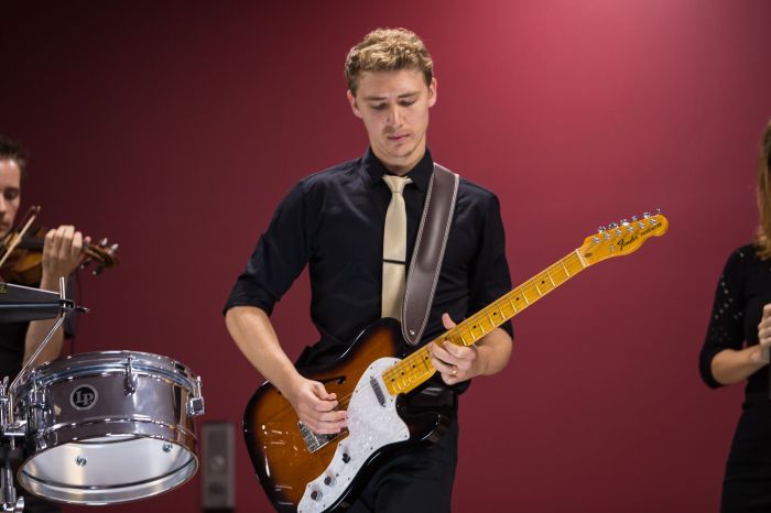 Michael Benhayon on stage playing guitar